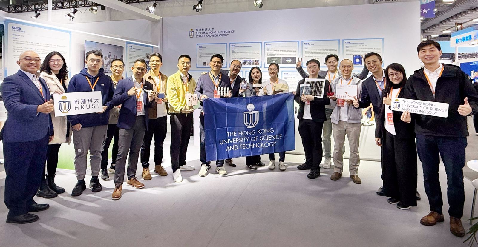 HKUST team group photo at exhibition with HKUST banner